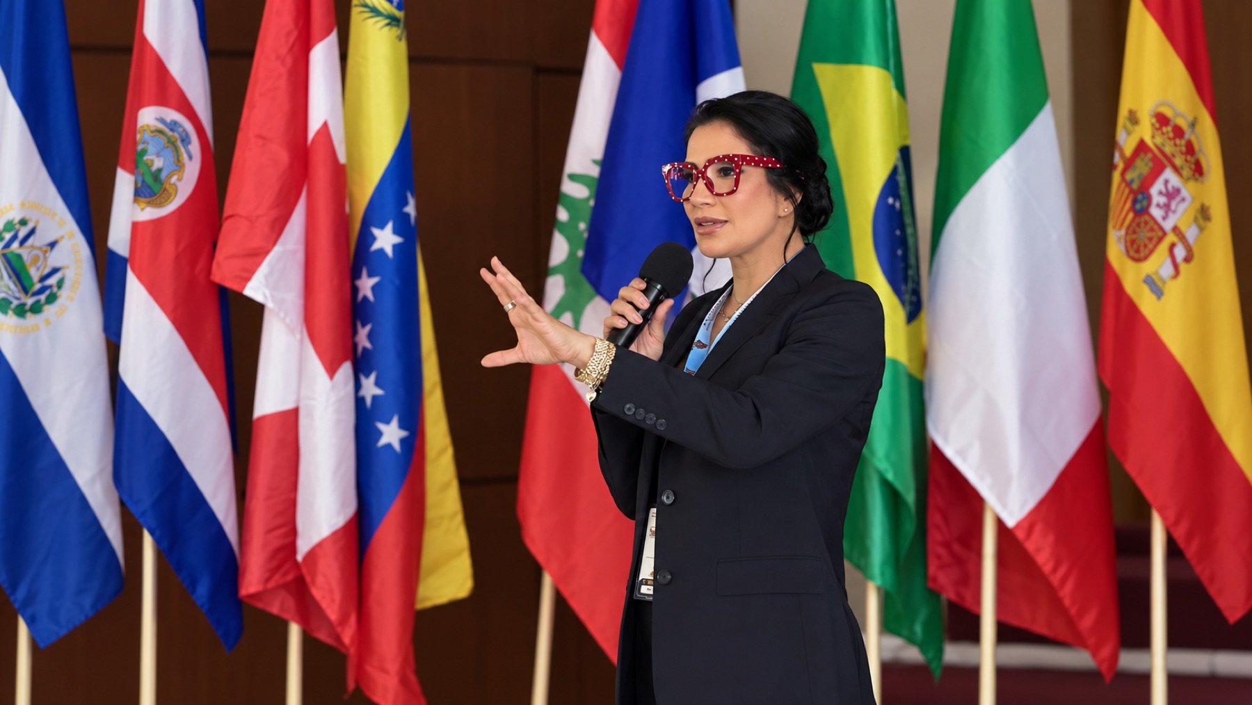 Zoé Gamboa impartiendo una conferencia ante banderas de distintos países